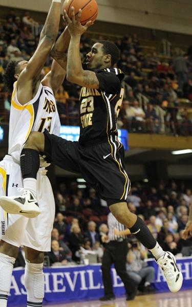 Freshman Mike Neal puts up a runner over senior Aloysius Henry in Appalachian's 65-55 loss to UNCG in the second round of the SoCon tournament.  Paul Heckert  |  The Appalachian 