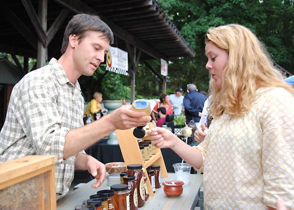 Local beekeeper Ryan Higgs serves a sample of honey to junior nursing major Emily Williams at the Watauga County Farmers' Market Saturday morning. The market is currently open Saturday and Wednesday mornings from 8:00 a.m. to noon at Horn in the West. Olivia Wilkes | The Appalachian 