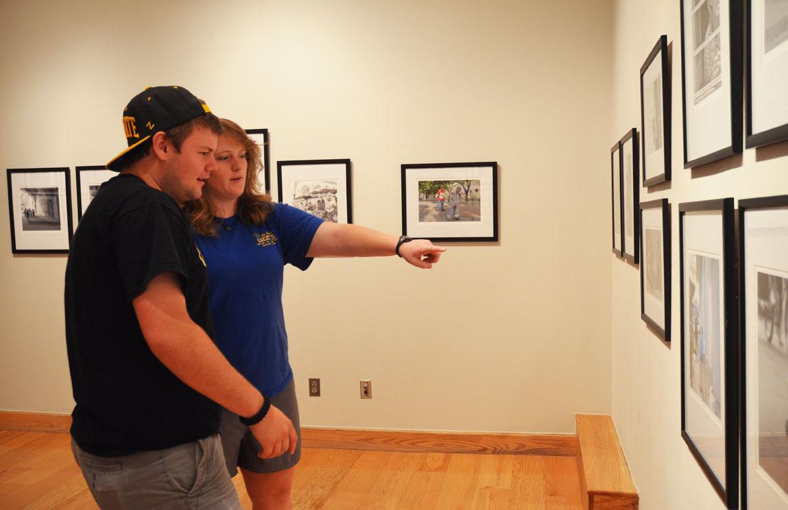 Sophomore public relations major Davis Coster and junior technical photography major Rebecca Murray view the recently opened photo exhibition in the Looking Glass Gallery. Murray was a contributing photographer to the gallery, which is a photo display of street life in Havana, Cuba.  Maggie Cozens | The Appalachian