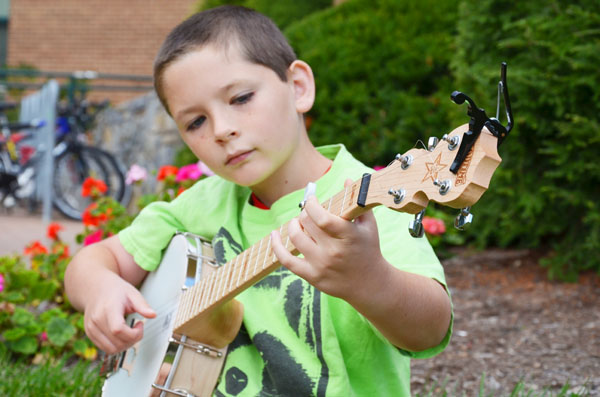 Ten-year-old Liam Purcell, son of Professor William Purcell, can play five instruments and has played on King street and at other venues. At September's First Friday Art Crawl, Liam Purcell made $102 playing banjo on the street. Michael Bragg | The Appalachian  