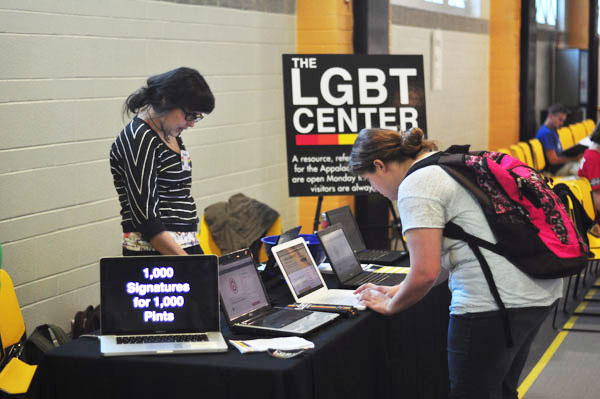 Junior biological anthropology major Elaine Blevins informs junior history education major Jackie Myers about the LGBT Center’s 1000 Signatures for 1000 Pints petition as Jackie views the petition online. Joey Johnson | The Appalachian