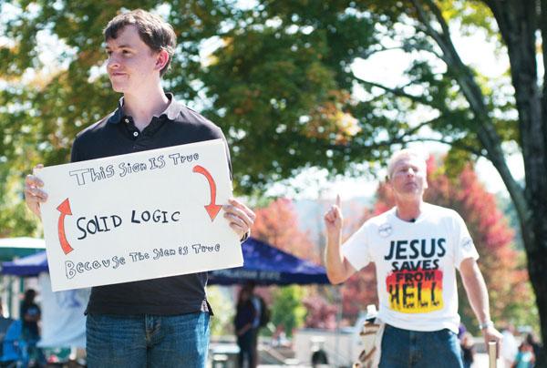 Junior biology major Johnathon Flippen holds up his sign during the silent protest against the preachers Wednesday afternoon. The protest was organized by the Appalachian Association Athesist/Agnostic club. 