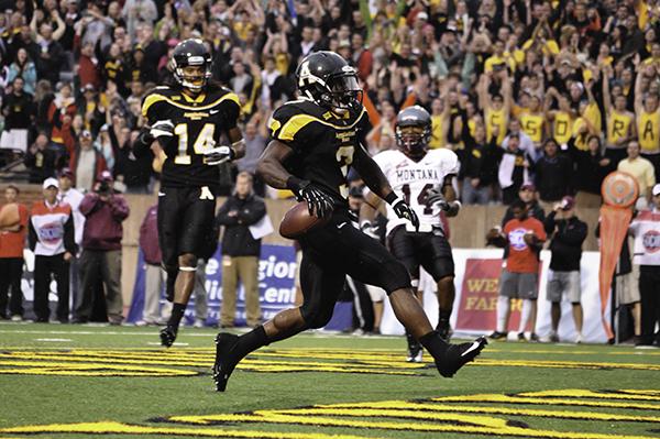 Senior running back Steven Miller races down the field with the ball in Saturday night's match against Montana. The Mountaineers emerged victorious with a score of 35-27. Justin Perry | The Appalachian