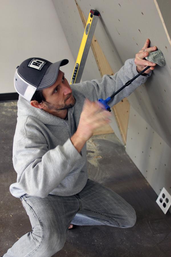 Rio Sawhill, co-owner of Regear Outdoors Co. sets routes on the in-store bouldering wall. Regear will offer outdoor gear and clothing on consignment and open its doors Tuesday. Paul Heckert | The Appalachian