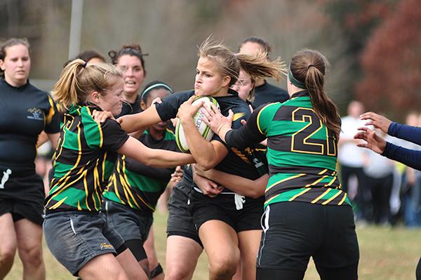 A member of the women's rugby team breaks through several defenders in a match during Rucktoberfest last semester. The men and women's teams are gearing up for the spring season.
