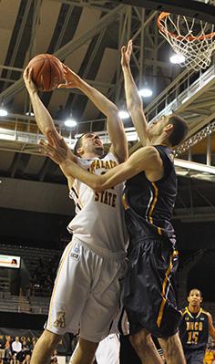 Senior forward Nathan Healy shoots over a defender during last nights game against UNCG. The Mountaineers came back in the second half to defeat the Spartans 83-70.