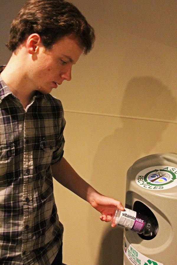 Freshman Dustin Parlier recycles a bottle in the new single stream bins.  Paul Heckert | The Appalachian 