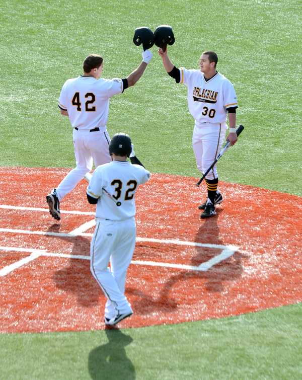 Junior infielder Noah Holmes (left) congratulates freshman Dillon Dobson on his home run against Canisius College Monday afternoon. The Mountaineers defeated the Golden Griffins 13-5.  Olivia Wilkes | The Appalachian