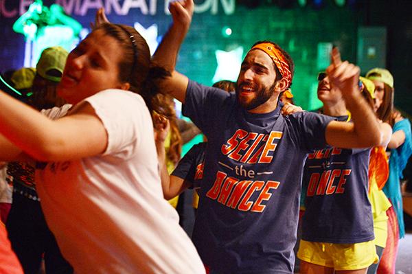 Junior risk management and insurance major Zach Yllanes throws his hands in the air during a congo line Saturday afternoon at Dance Marathon. The event took place in Legends for 15 hours and raised $26,530.98.  Olivia Wilkes | The Appalachian