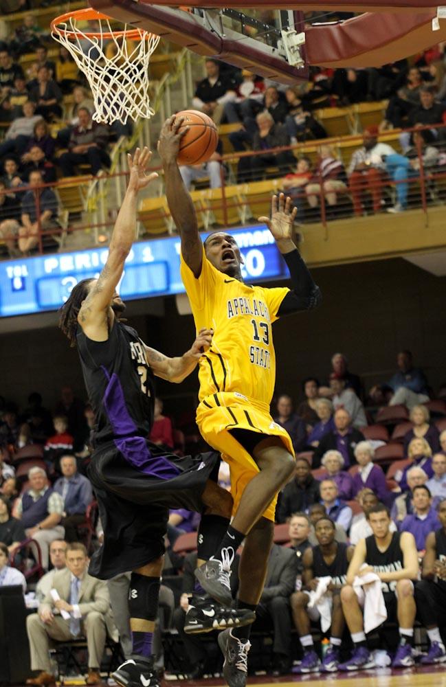 Senior forward Jamaal Trice attempts a layup against a Furman defender in Saturday’s second round of the SoCon Tournament against Furman University. The Mountaineers won 74-60 and secured their advance to the semifinal where they will play Davidson Sunday at 6 p.m.  Paul Heckert  |  The Appalachian 