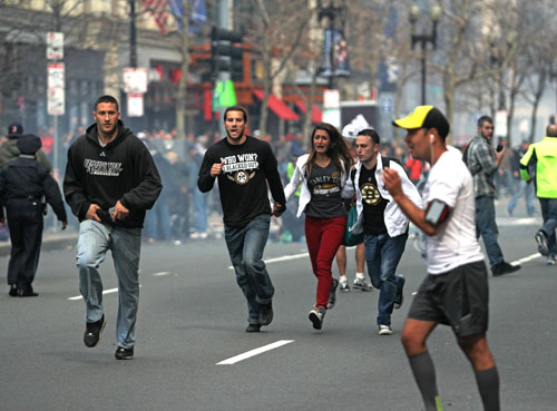 Spectators flee from the scene of the first of two explosions that shook the finish line of the 117th Boston Marathon near Copley Square on Monday afternoon. The bombings left three dead and 140 injured as of press time.  Kenshin Okubo | Daily Free Press 