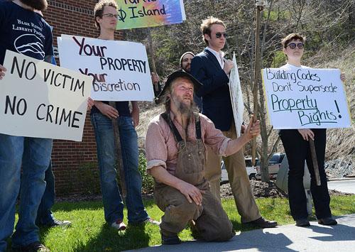 Owner of Turtle Island Preserve, Eustace Conway, speaks in front of the Watauga County Health Department surrounded by a group of supporters. A group of community members and students organized the march, which began at Sanford Mall.  Olivia Wilkes  |  The Appalachian