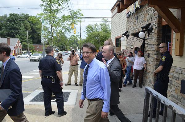 Gov. Pat McCrory leaves Mellow Mushroom on Friday while protesters and supporters stand outside. McCrory stopped by the pizza restaurant for a meet and greet after speaking at the second annual Appalachian Energy Summit at Appalachian State University.  Michael Bragg  |  The Appalachian