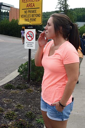Senior psychology major Lindsay Livengood takes a smoke break at College Street Circle. This is a newly enforced designated smoking area as of fall 2013.  Photo by Courtney Roskos  |  The Appalachian