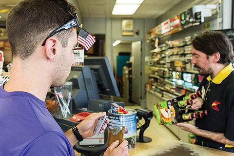 Junior economics major Chris Zino prepares to hand Kangaroo Express employee, Jesse Steele, his ID to purchase a six-pack of beer. Throughout the summer the Watauga Substance Abuse Prevention Collaborative has conducted compliance checks with local business to determine if they will provide underage persons with alcohol. Photo by Paul Heckert  |  The Appalachian