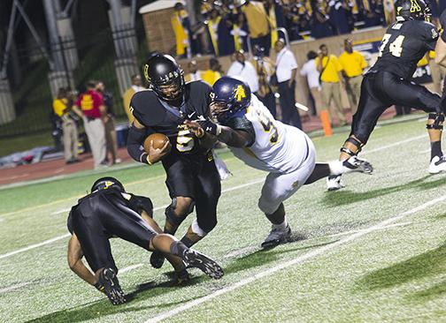 Sophomore quarterback Kameron Bryant brushes off a tackle from an N.C. A&T defender in Saturday night's game. Despite a fourth quarter comeback, the Aggies held off the Mountaineers for a 24-21 win. Photo by Paul Heckert  |  The Appalachian