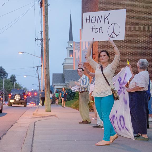 Senior political science major Jenny Church holds a sign advocating for peace during MoveOn’s vigil Monday against a United States military strike in Syria. Photo by Justin Perry  |  The Appalachian