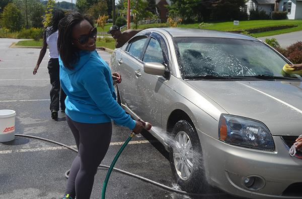 Senior exercise science major Shelita Richmond of the National Pan-Hellenic Council at Appalachian State washes cars Saturday at Advanced Auto Parts. Participants from seven sororities and fraternities took part in the car wash, which was held to raise money for Hazing Prevention Week. Photo by Maggie Cozens | The Appalachian