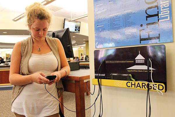 Junior nutrition major Alaina Stacy charges her phone at the first floor  "Get Charged" station in Belk Library Tuesday.  The "Get Charged" stations are complete with cell phone chargers for most models."I lose my cords all the time," Stacy said, "so the charging stations are very convenient." Photo by Molly Cogburn  |  The Appalachian