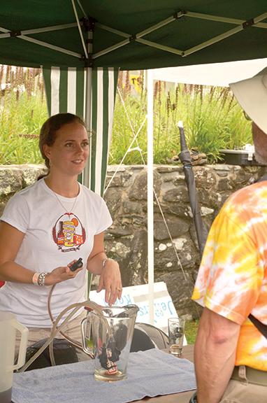 Carolyn Ward speaks with a patron about her father’s homemade beer. Ward’s father, Andy Mason, has been brewing beer for almost 25 years. Photo by Chelsea Fisher  |  The Appalachian