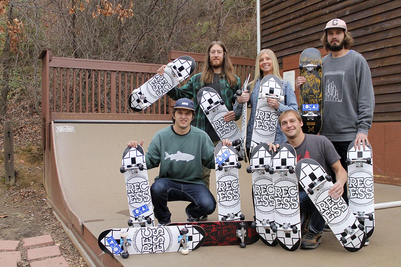 Wade Montgomery and Pete DeRose, owners of Local and sponsors of Afford a Board, purchased 13 skateboards from Recess, owned by J.P. Pardy, to donate to less fortunate children unable to buy skateboards. (From top left to right) J.P. Pardy, Ashley Pardy, Wade Montgomery, Pete DeRose and Phill Baldwin show the skateboards being given to the children outside of Recess on the skate ramp. Photo by Molly Cogburn  |  The Appalachian