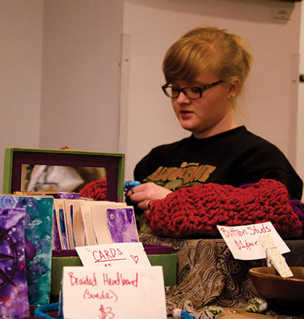 Lindsey Hoffman, sophomore sociology major, crochets at her table in the Old Time Fiddler's Convention craft market. The market draws artisans from the community each year. Photo by Kim Reynolds | The Appalachian