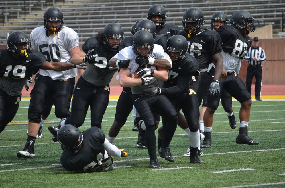 Junior wide receiver Simms McElfresh fights off a group of tacklers during a full-contact spring scrimmage last Saturday at Kidd Brewer Stadium.  Photo by Corey Spiers  |  The Appalachian