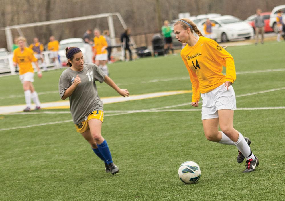 Sophomore forward Samantha Childress (right) dribbles around a Mars Hill defender in the opening game of Appalachian State’s spring schedule. The Mountaineers won 6-0.  Photo by Paul Heckert  |  The Appalachian
