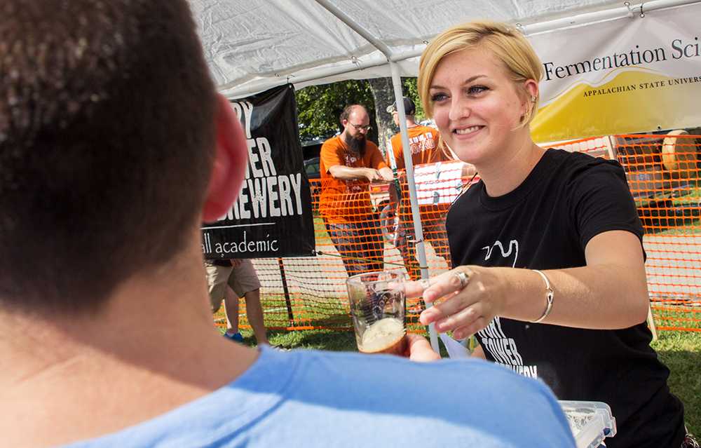 Senior fermentation science major Emily Williams prepares to fill a thirsty festival goers glass with a Stout Float a combination of stout beer and ice cream